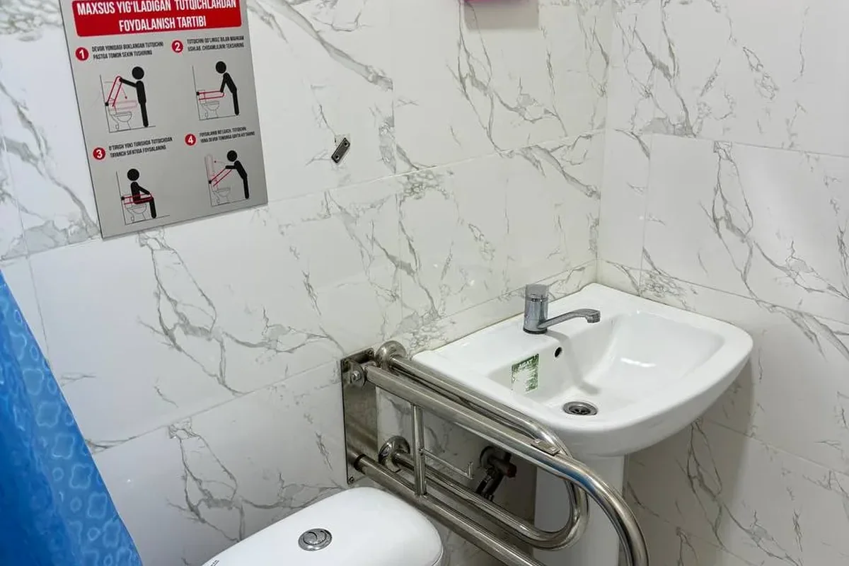 Interior · Sink in the accessible toilet — with support handrails around it, so a wheelchair user can use it with support.