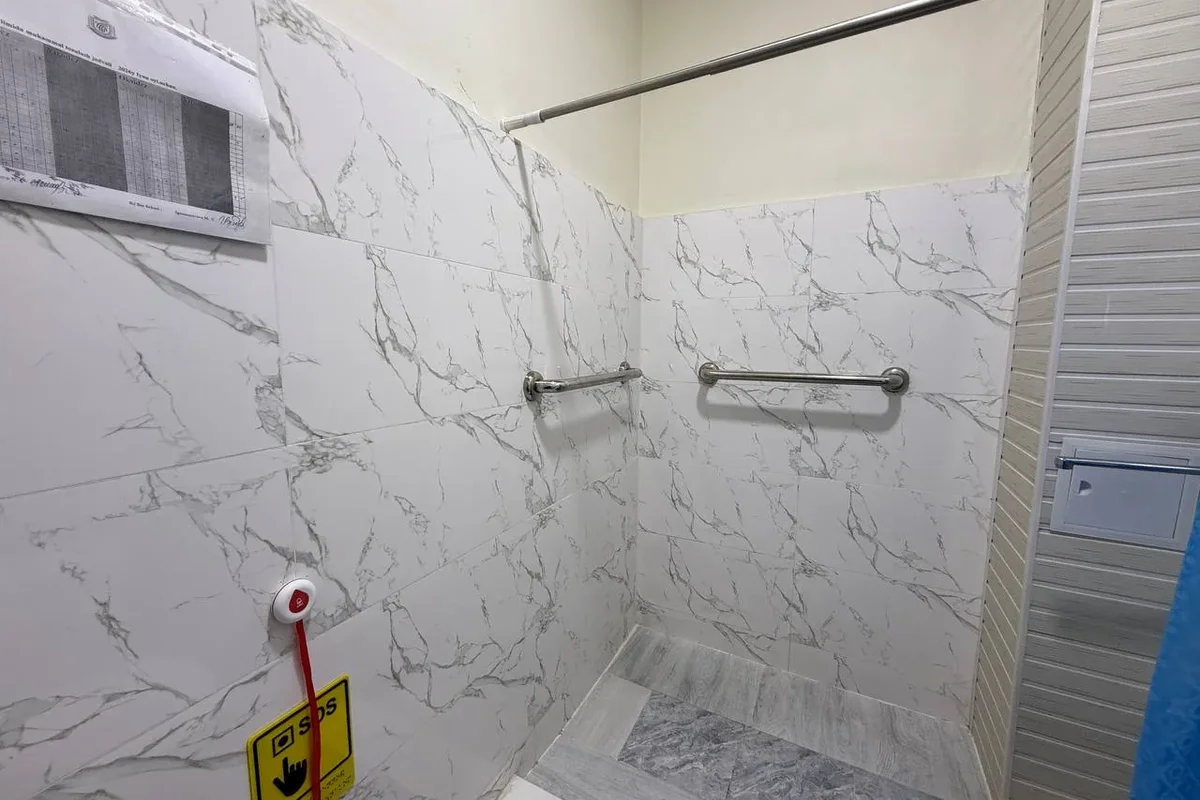 Interior · Accessible shower room — support rails and an SOS button; for safe washing and emergency assistance.