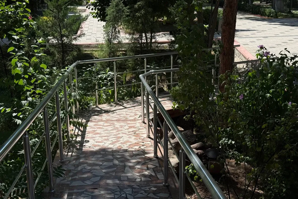 Exterior · Ramp with handrails in the courtyard — so wheelchairs and the elderly can safely overcome the height difference on the grounds.