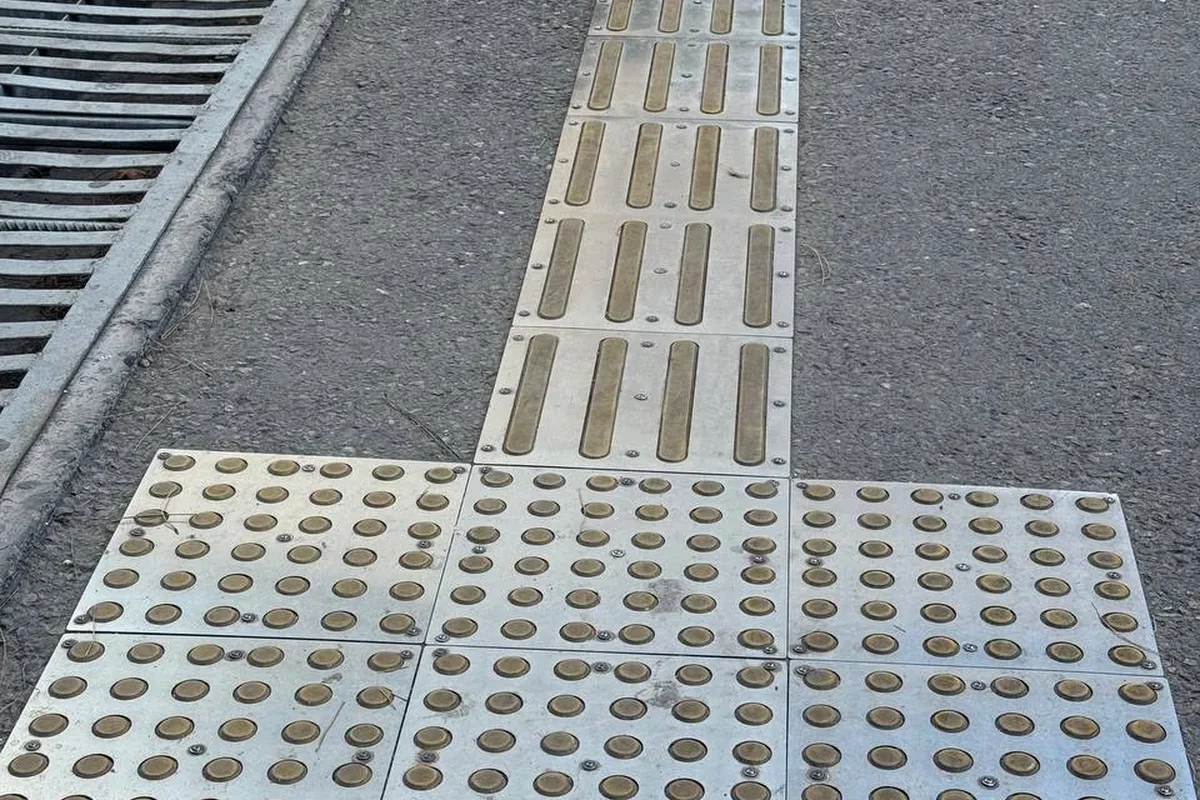 Exterior · Tactile paving indicators on the grounds — so visually impaired patients can sense the direction through the underfoot path.